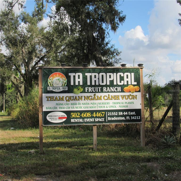 A large sign for TA Tropical Fruit Ranch stands outdoors in a grassy field — 21552 E STATE ROAD 64, BRADENTON, FL