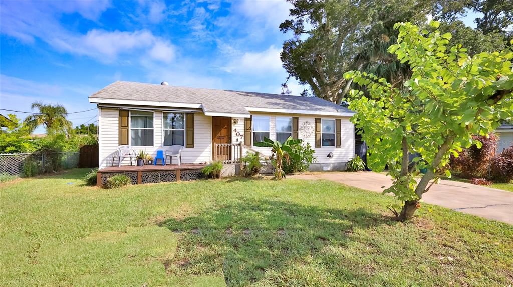 A single-story house with light siding, a front porch, and a grassy yard — 407 ANN STREET, EDGEWATER, FL