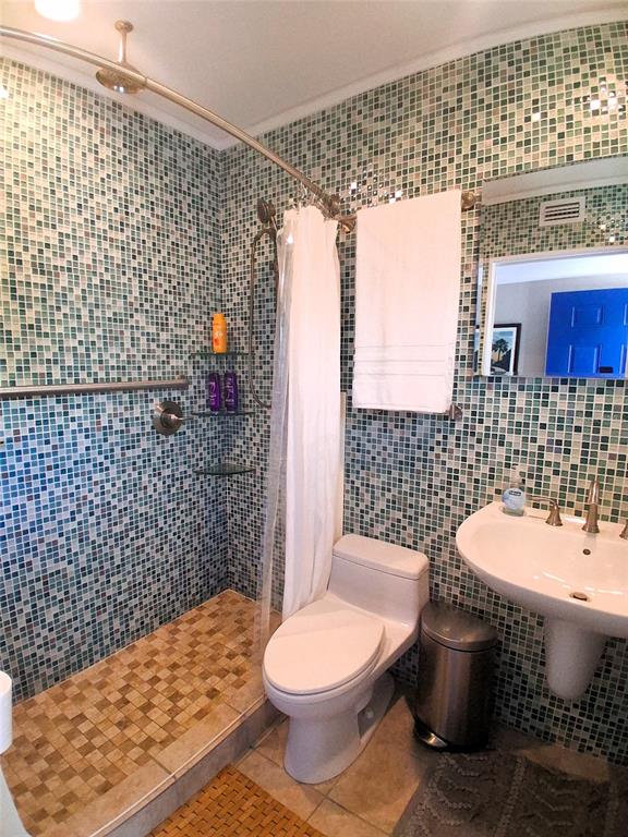 A bathroom features a walk-in shower with mosaic tile walls and a pedestal sink — 2850 GULF OF MEXICO DRIVE UNIT 2, LONGBOAT KEY, FL