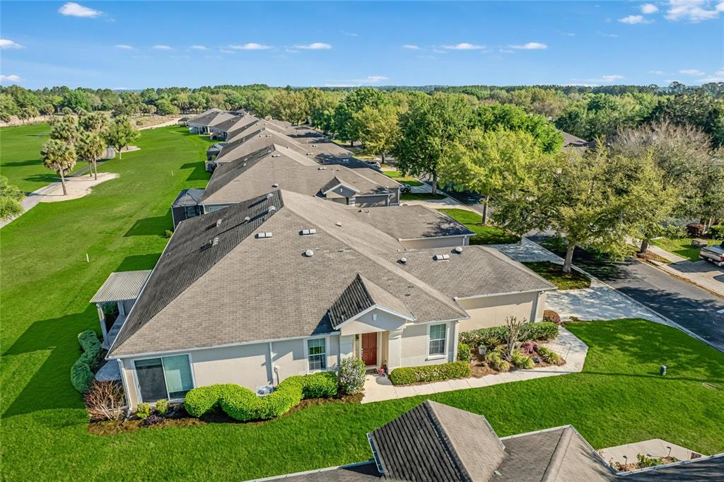 An aerial view shows a row of attached houses bordering a green golf course — 9565 SW 70TH LOOP, OCALA, FL