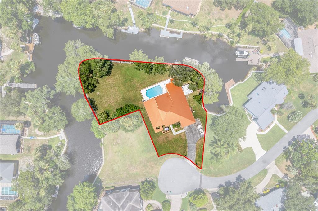 An aerial view shows a house with a pool and a large yard on a canal — 11649 W CLUBVIEW DRIVE, HOMOSASSA, FL