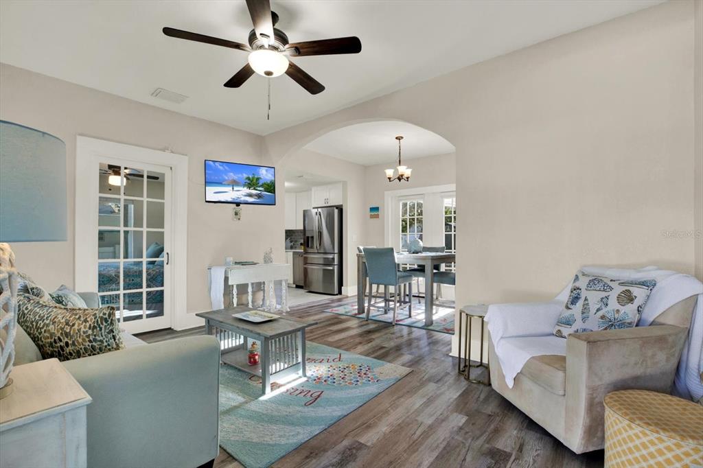 A living room with a ceiling fan, television, and an arched opening to a dining area — 1945 OVERBROOK AVENUE, CLEARWATER, FL