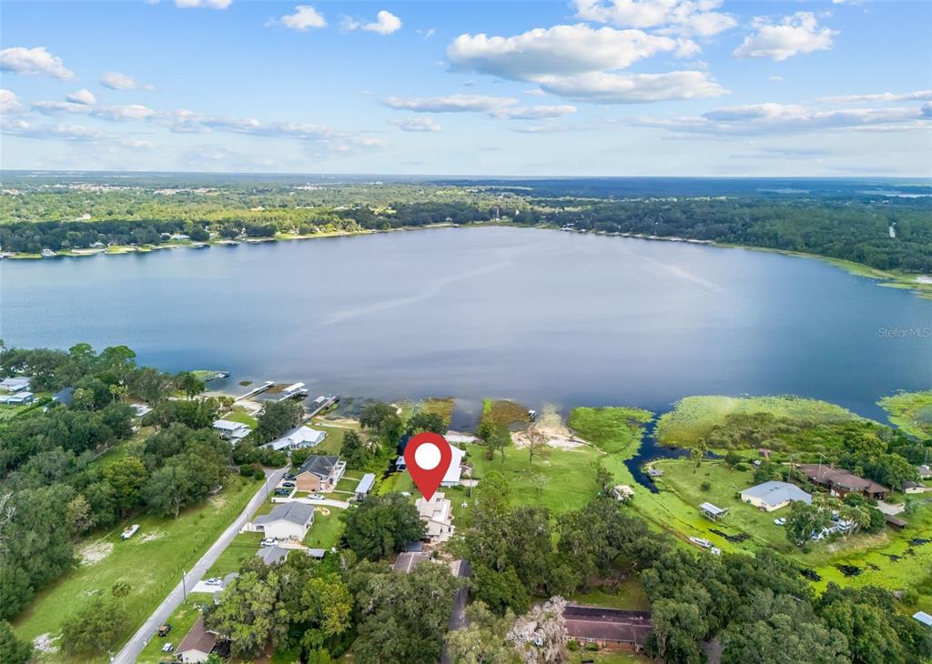 An aerial view shows a house with a red location pin beside a large lake — 14478 SE 107TH TERRACE, SUMMERFIELD, FL