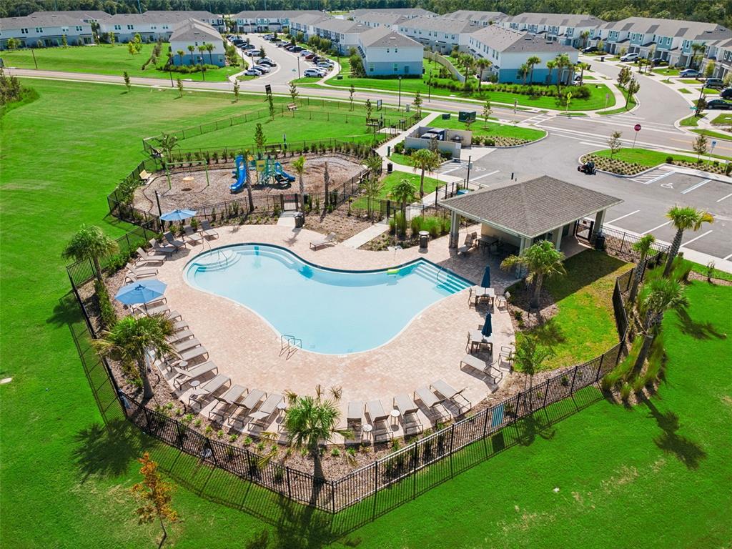 An aerial view of a community swimming pool, playground, and covered patio area — 2251 PORTRAIT STREET, POINCIANA, FL
