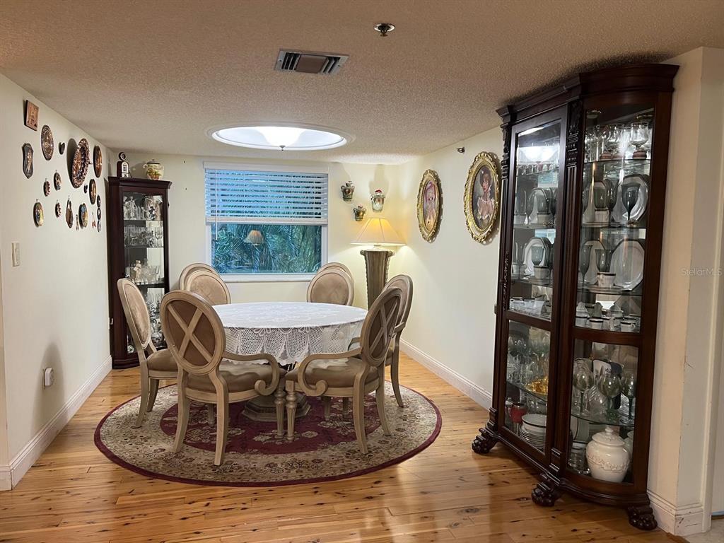 A dining room features a round table with chairs, two china cabinets, and a skylight — 3910 INVERRARY BOULEVARD UNIT B301, LAUDERHILL, FL