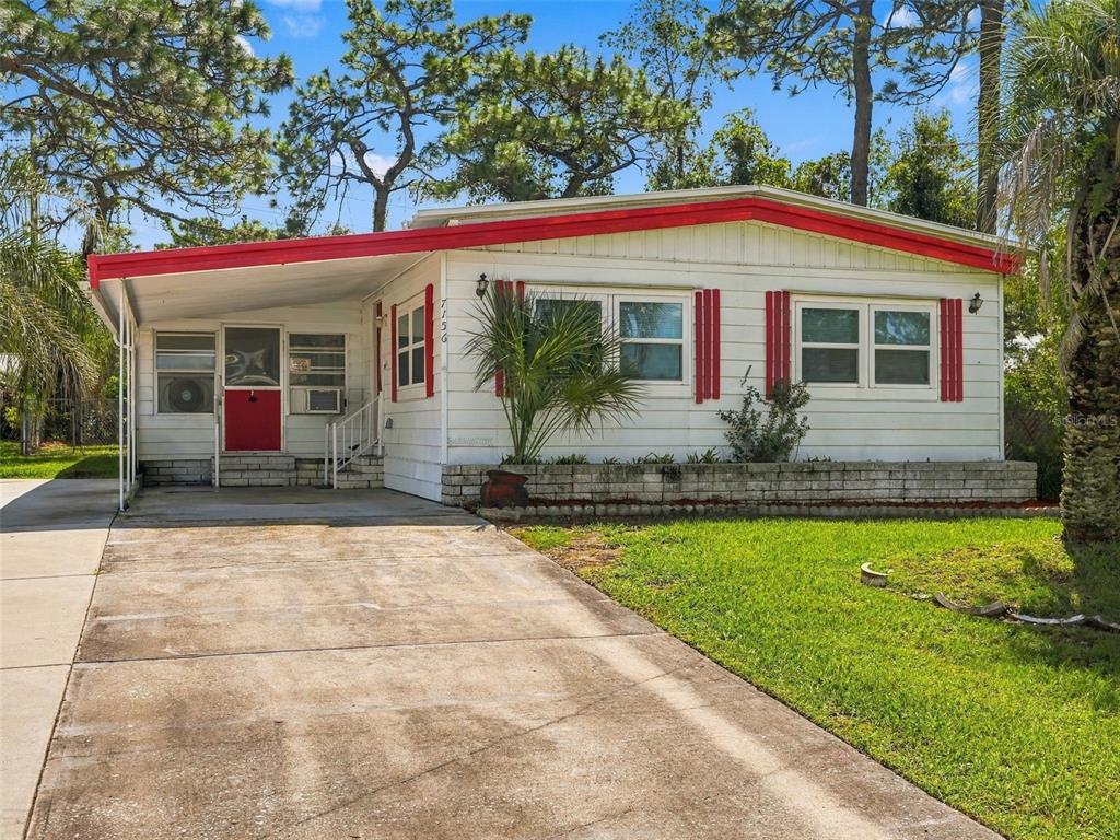 A single-story mobile home with white siding, red trim, and a concrete driveway — 7156 FITZPATRICK AVENUE, BROOKSVILLE, FL