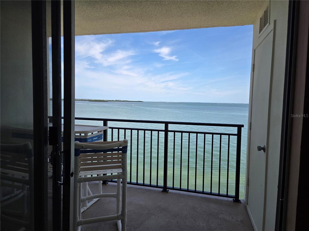 A balcony with a black metal railing overlooks a wide body of water — 9 HAIG PLACE UNIT 405, DUNEDIN, FL