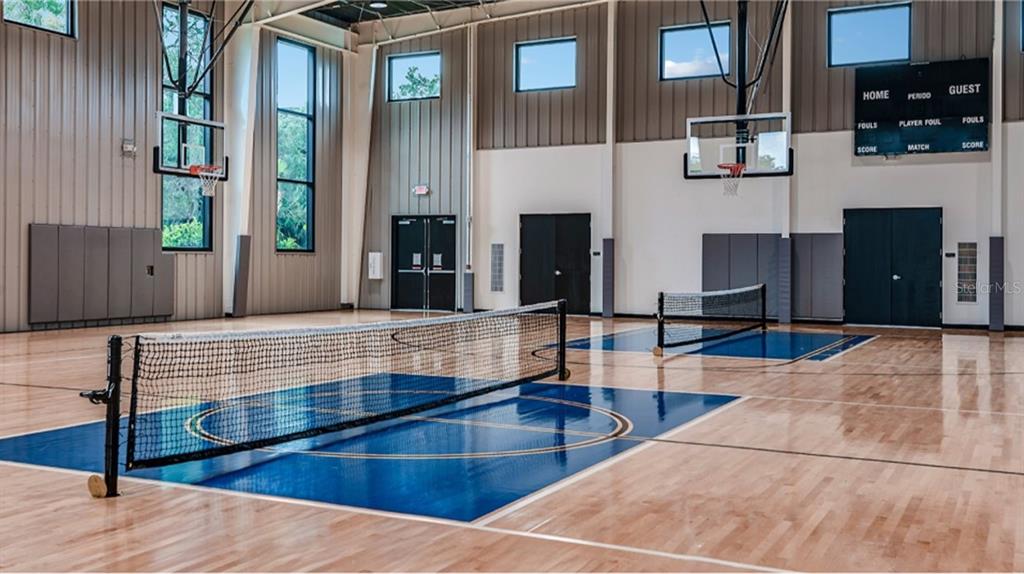 An indoor sports court features two pickleball nets, basketball hoops, and a scoreboard — 4493 OCHOS RIOS PLACE, KISSIMMEE, FL