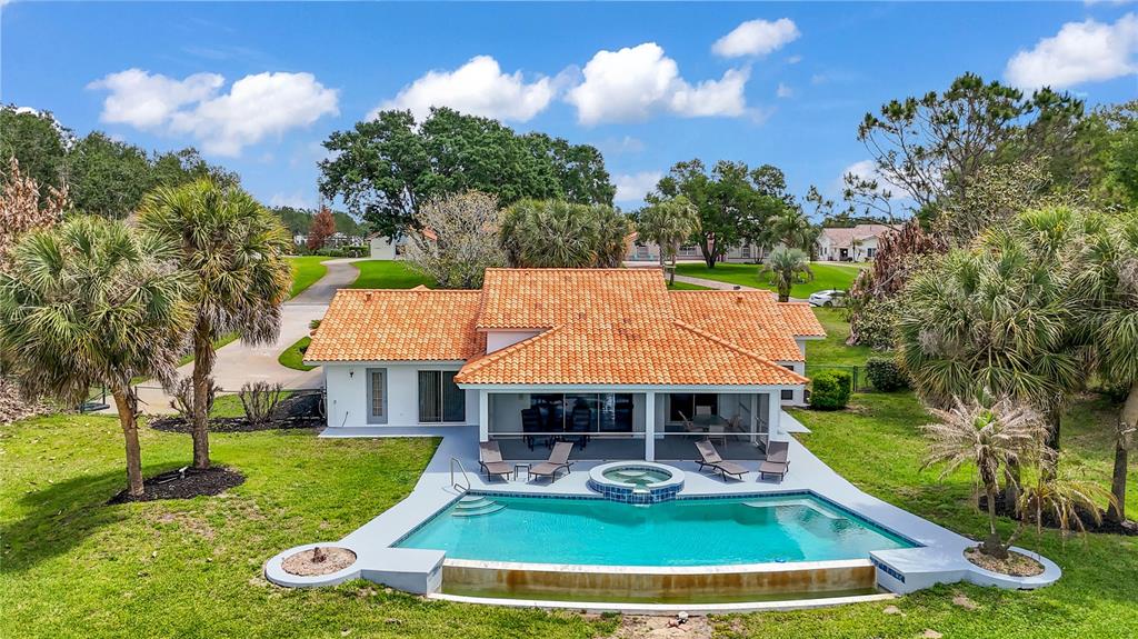 An aerial view of a house with a terracotta roof, a swimming pool, and landscaping — 12853 BELLERIVE DRIVE, CLERMONT, FL