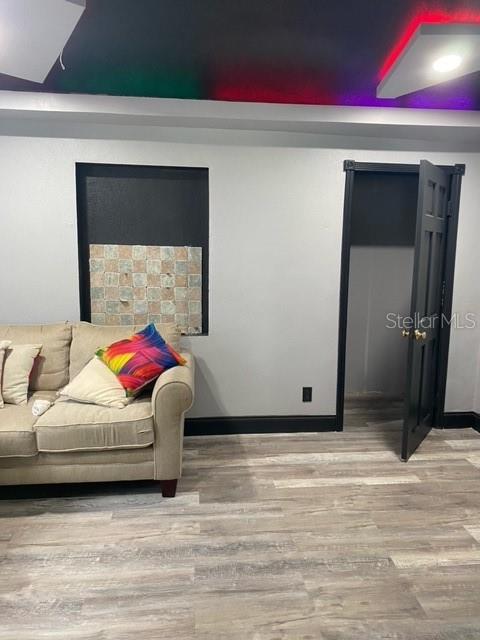 A living room features a beige sofa, light wood-look flooring, and a black closet door — 3100 EUNICE AVENUE, ORLANDO, FL