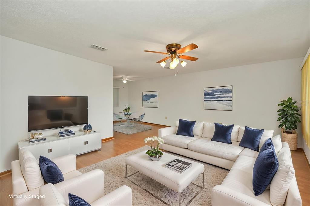 A living room features a white sectional sofa, a coffee table, and a television console — 9881 SW 101ST PLACE, OCALA, FL