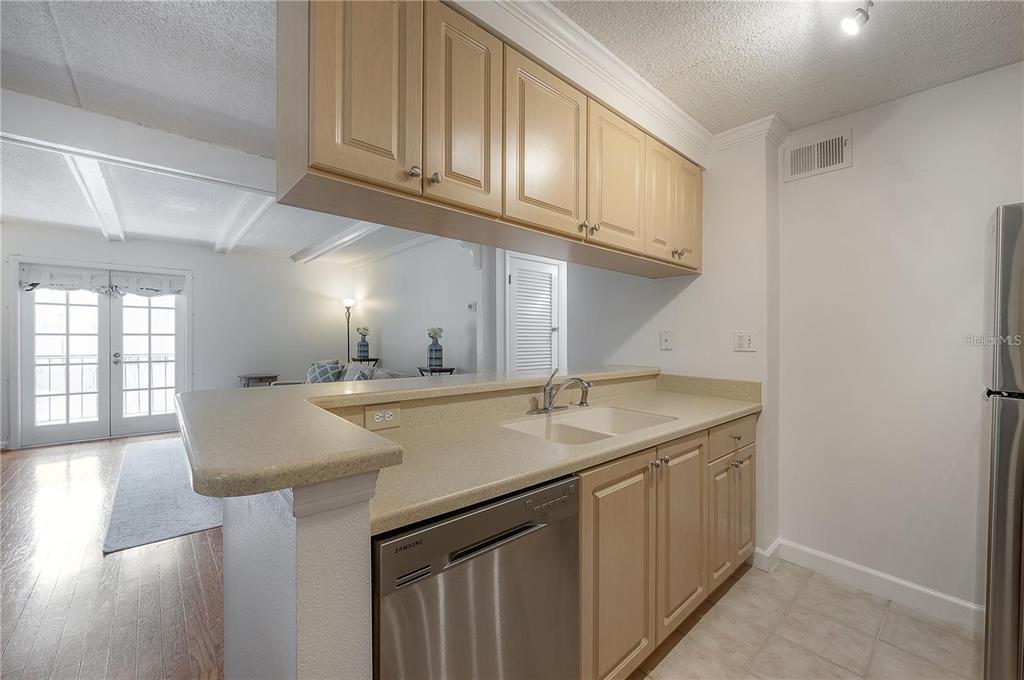 A kitchen features light wood cabinets, a stainless steel dishwasher, and a breakfast bar counter — 107 S OBRIEN STREET UNIT 218, TAMPA, FL