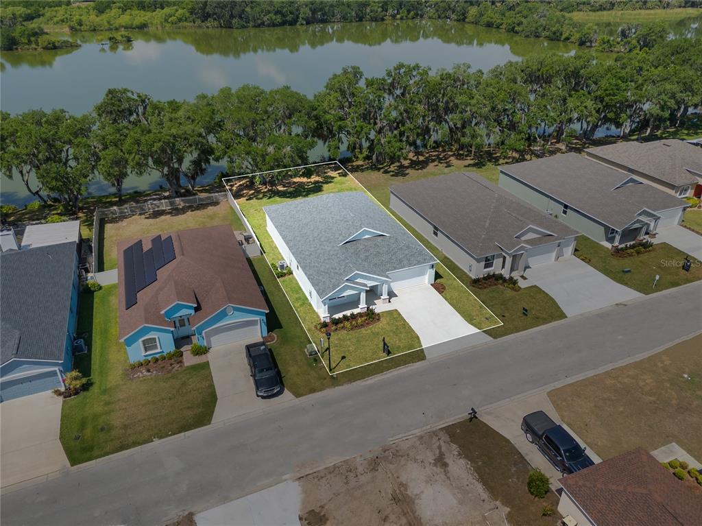 An aerial view shows a single-story house with a white exterior and gray roof — 4545 FAIRWAY OAKS DRIVE, MULBERRY, FL