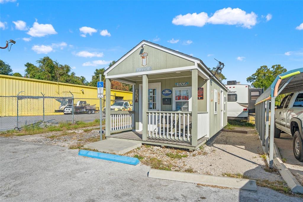 A small, light green office building with a front porch sits on a gravel lot — 9539 STATE ROAD 52, HUDSON, FL