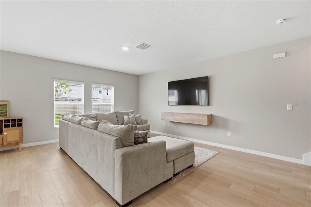 A light blue front door with a welcome mat sits on a concrete porch — 12950 PASTURE WOODS PLACE, LITHIA, FL