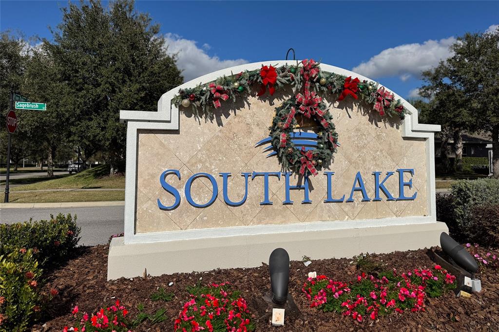 A decorative stone monument sign for South Lake is adorned with a festive holiday wreath — 3470 SAGEBRUSH STREET, HARMONY, FL