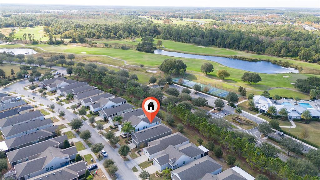 An aerial view shows a residential neighborhood with a marked house near a golf course — 3470 SAGEBRUSH STREET, HARMONY, FL