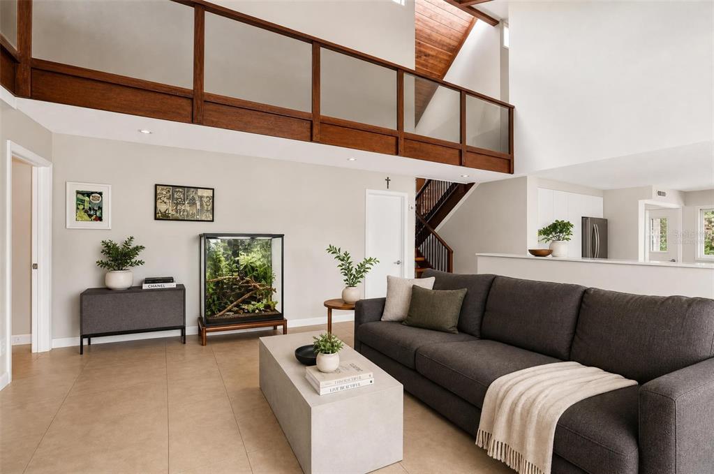 A modern living room features a dark gray sofa, a concrete coffee table, and a terrarium — 310 HIDDEN LAKE DRIVE, BRANDON, FL