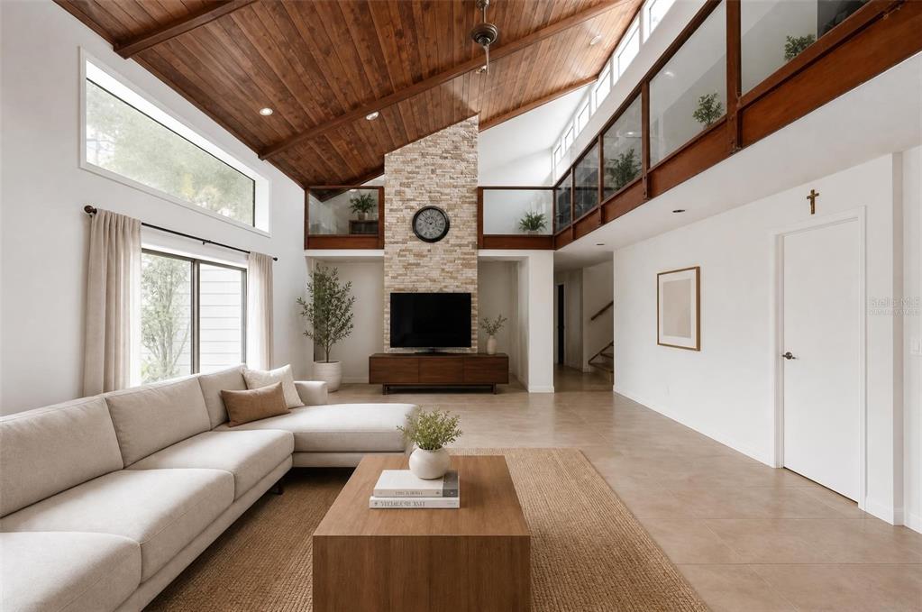 A living room features a vaulted wood ceiling, stone fireplace, and a lofted balcony — 310 HIDDEN LAKE DRIVE, BRANDON, FL