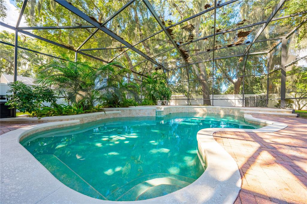 A bathroom features a soaking tub, a glass shower, and dual vanities with granite countertops — 1648 MARINA LAKE DRIVE, KISSIMMEE, FL