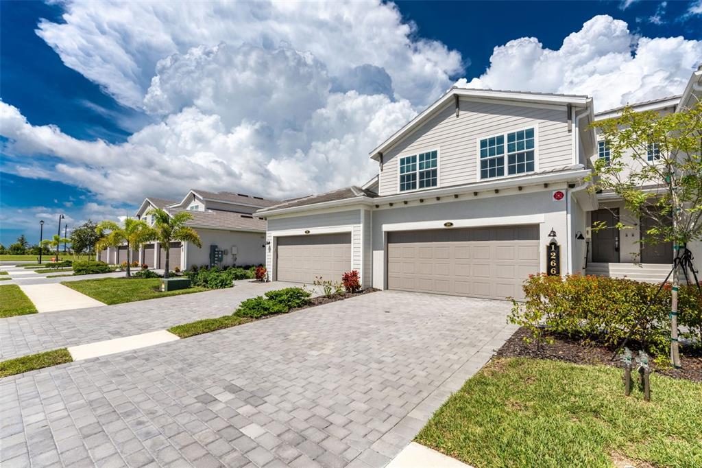 A two-story suburban house with a paved driveway, two-car garage, and light-colored siding — 12660 RADIANCE COURT UNIT 201, VENICE, FL