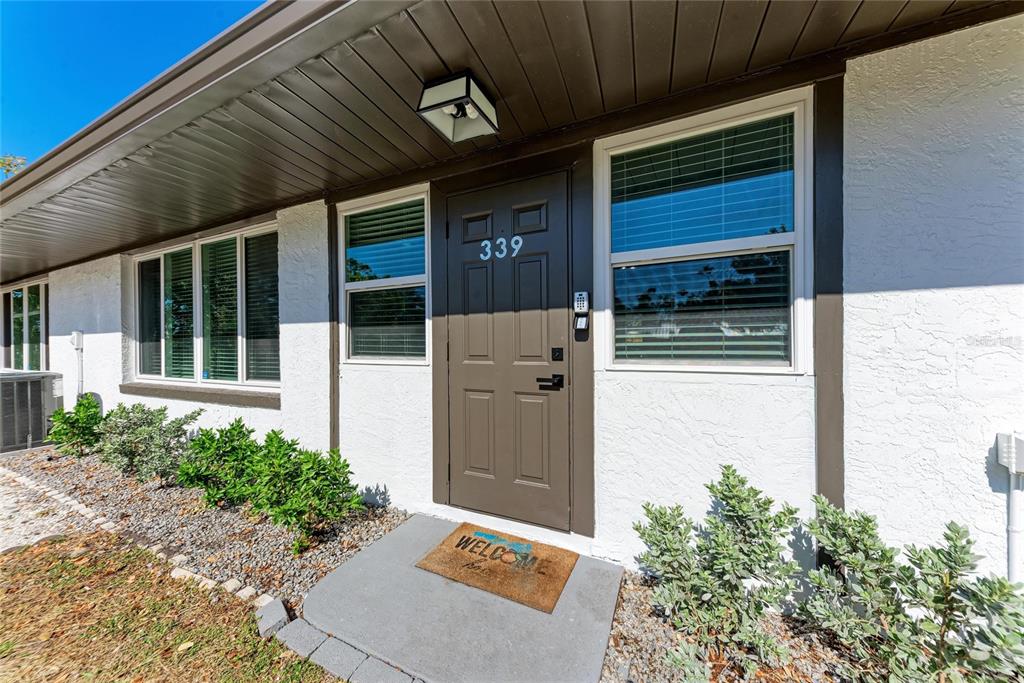A brown front door with the number 339 is centered on a white stucco exterior — 339 SUWANEE AVENUE, SARASOTA, FL