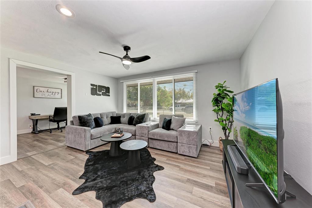 A living room features gray sectional seating, a black area rug, and a television — 339 SUWANEE AVENUE, SARASOTA, FL