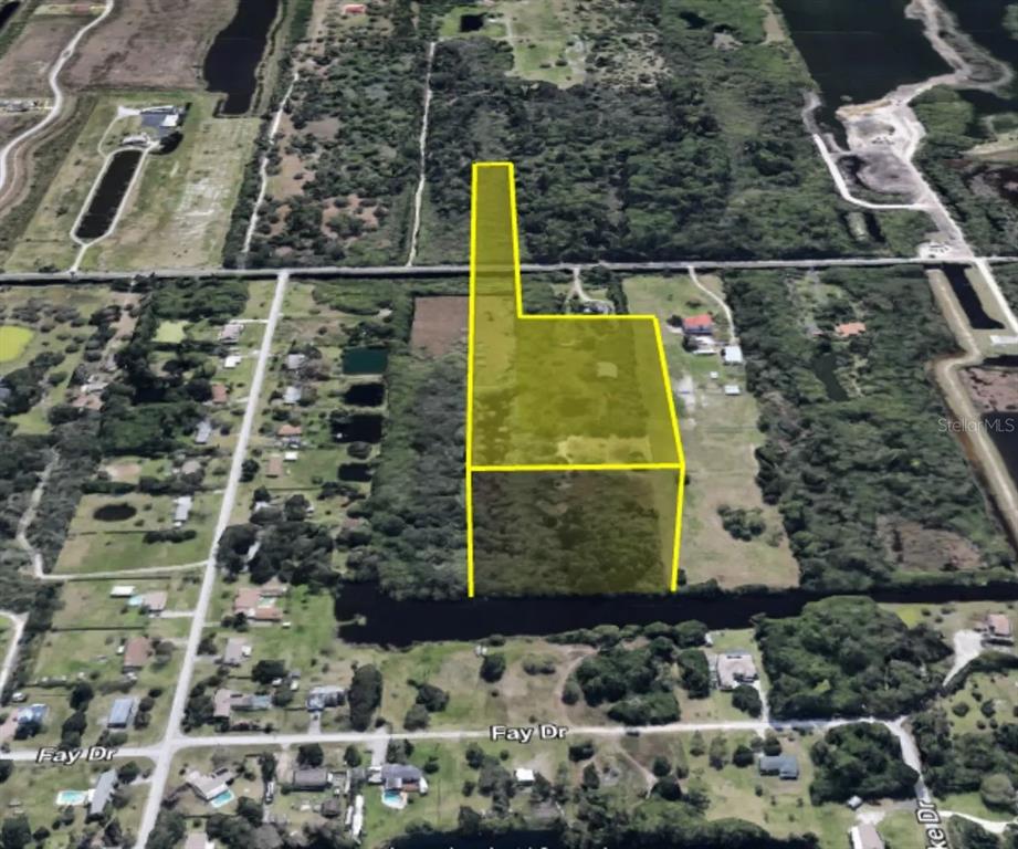 An aerial view shows a large, irregularly shaped vacant lot outlined in yellow — TBD PINE ISLAND ROAD, MERRITT ISLAND, FL