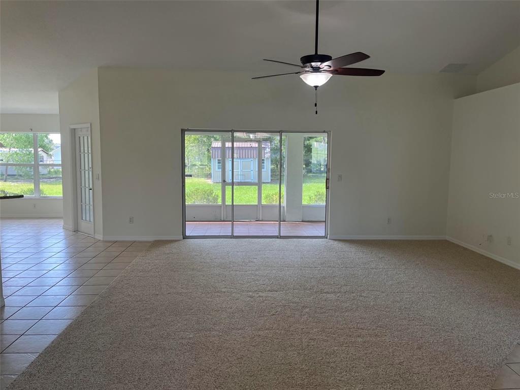 A spacious living room features a large sectional sofa, a coffee table, and neutral decor — 4949 SW 109TH LOOP, OCALA, FL