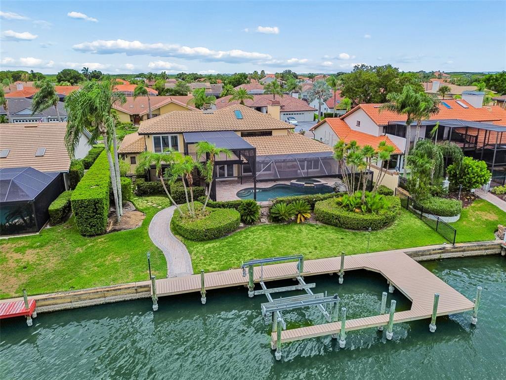 An aerial view of a waterfront house with a pool, screened lanai, and private dock — 9815 BAY ISLAND DRIVE, TAMPA, FL