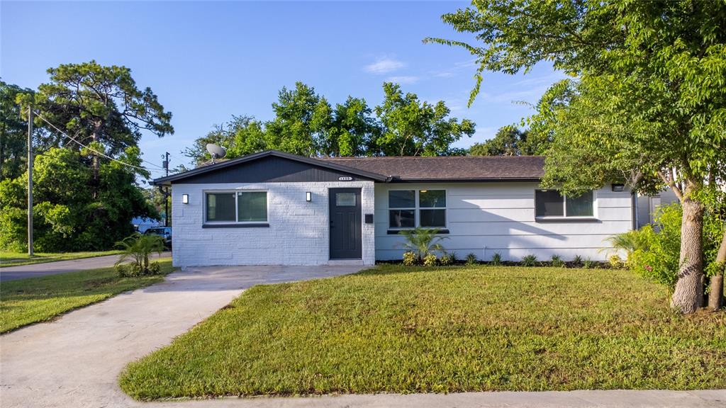 A single-story house with white painted brick, a dark front door, and a concrete driveway — 6400 MONTANA AVENUE, NEW PORT RICHEY, FL