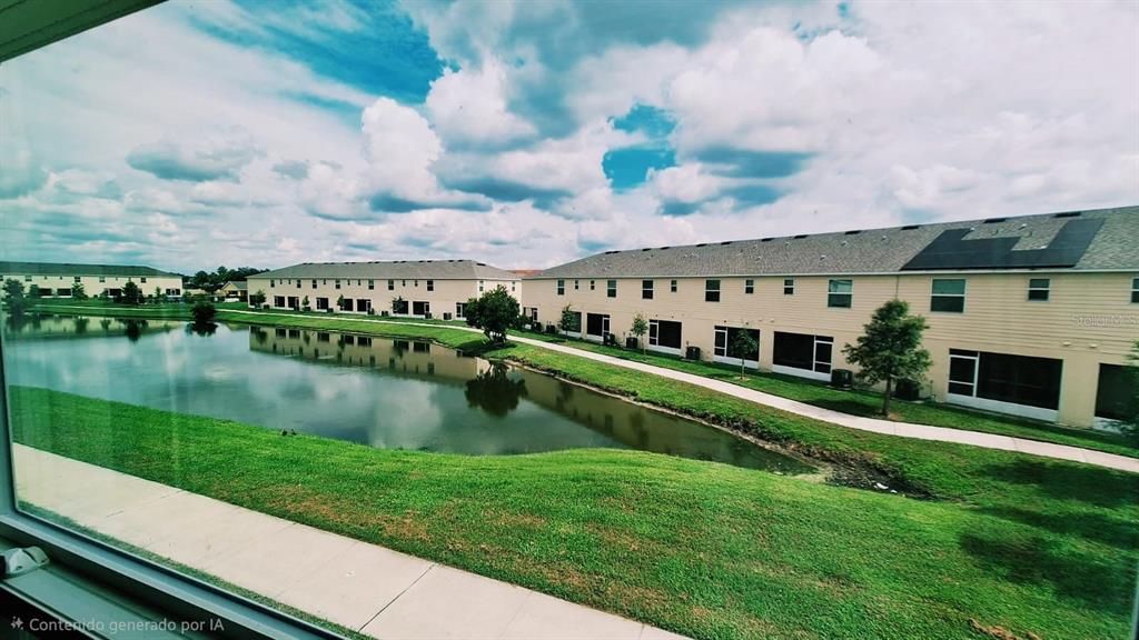 A view from a window overlooking a pond and multi-family residential buildings — 4812 CORAL CASTLE DRIVE, KISSIMMEE, FL