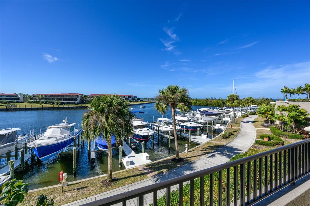 A view of a marina with docked boats and palm trees from a balcony — 3313 SUNSET KEY CIRCLE UNIT 104, PUNTA GORDA, FL