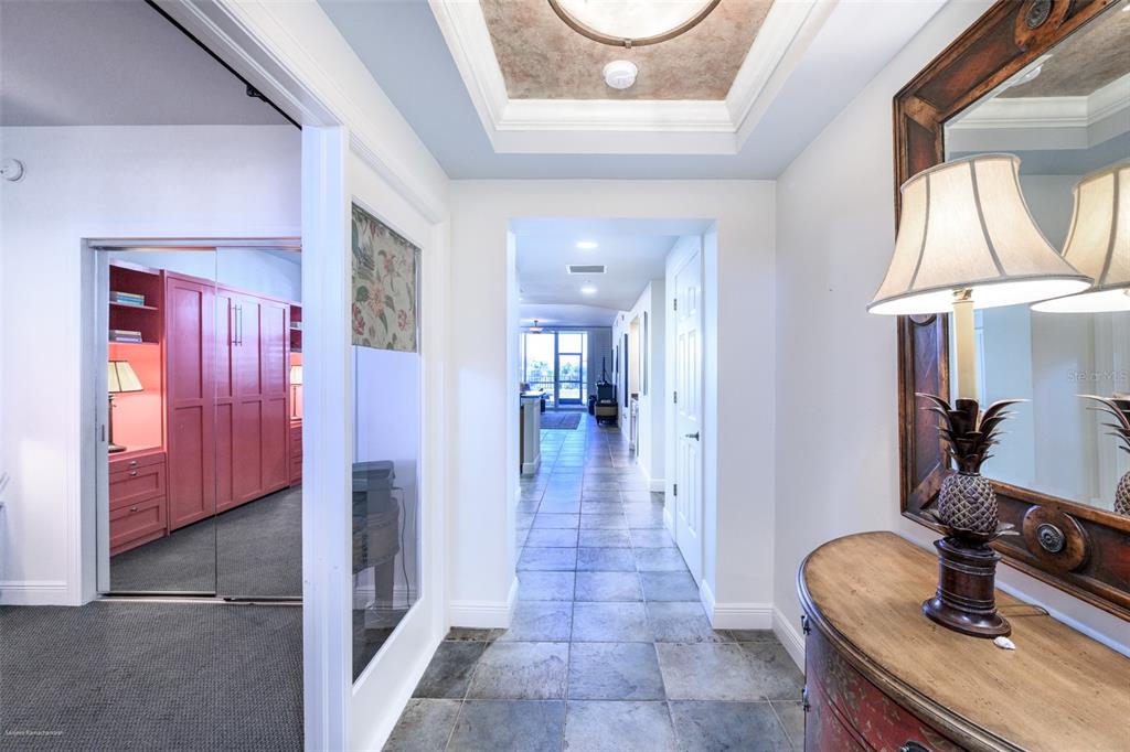 A tiled hallway leads toward a living area, with a mirrored room on the left — 3313 SUNSET KEY CIRCLE UNIT 104, PUNTA GORDA, FL