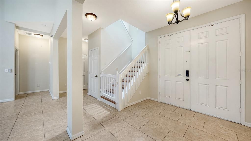 A two-story suburban house with a light-colored stucco exterior and an attached two-car garage — 208 36TH STREET NE, BRADENTON, FL