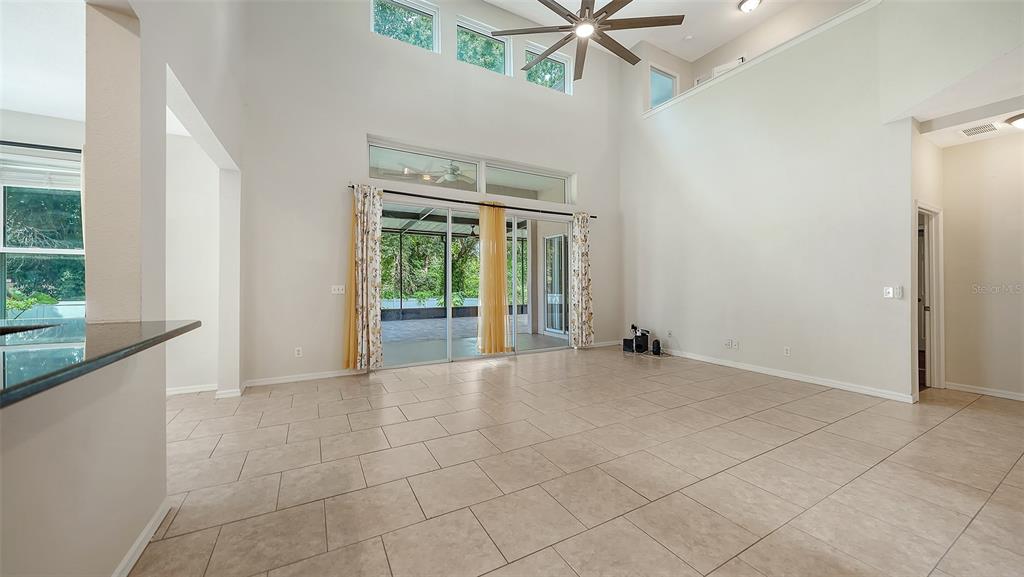 A two-story house with a pink exterior, a large tree, and a front garden — 208 36TH STREET NE, BRADENTON, FL