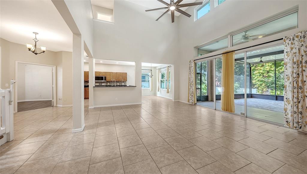 A two-story house with a light pink stucco exterior, arched entryway, and landscaped front yard — 208 36TH STREET NE, BRADENTON, FL