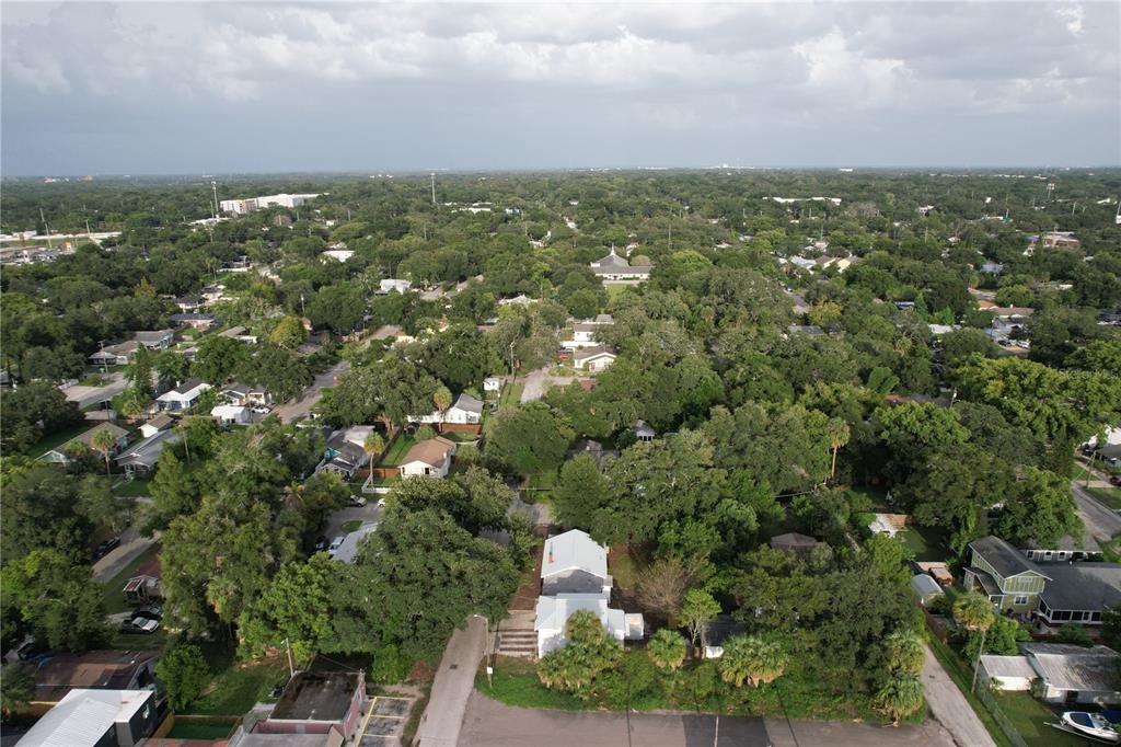 An aerial view shows a residential neighborhood with many trees and scattered single-family homes — 6506 N WELLINGTON AVENUE, TAMPA, FL