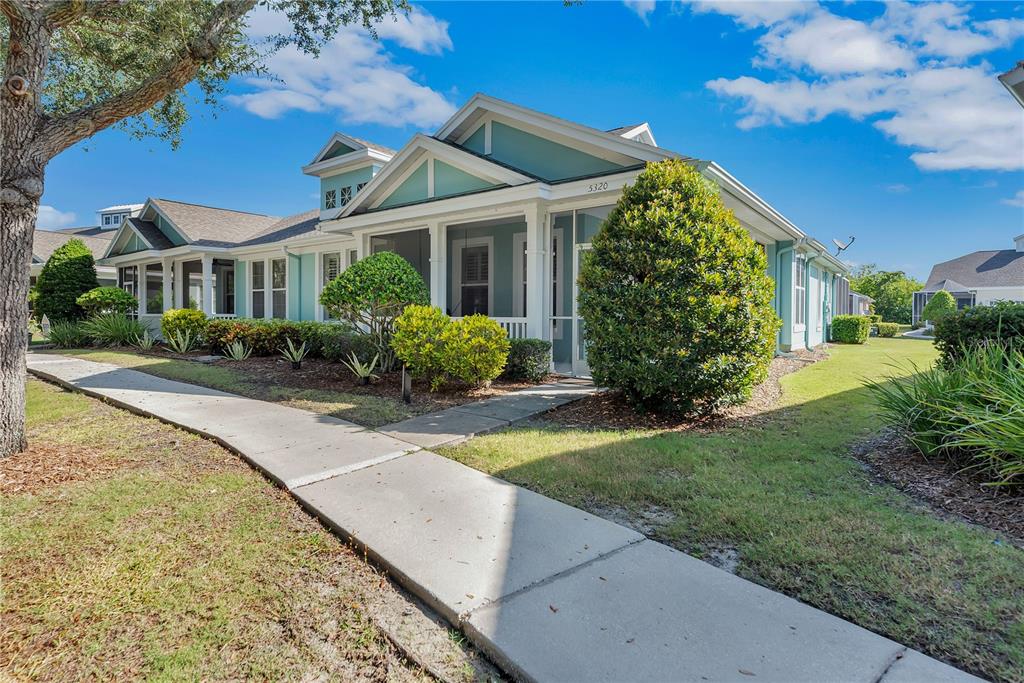 A light blue single-story house with a screened front porch and a concrete walkway — 5320 GOLDEN ISLES DRIVE, APOLLO BEACH, FL