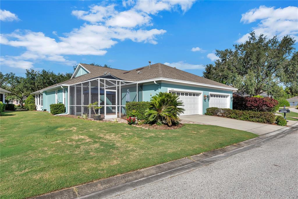 A light blue house with a screened-in patio and a two-car garage under a blue sky — 5320 GOLDEN ISLES DRIVE, APOLLO BEACH, FL