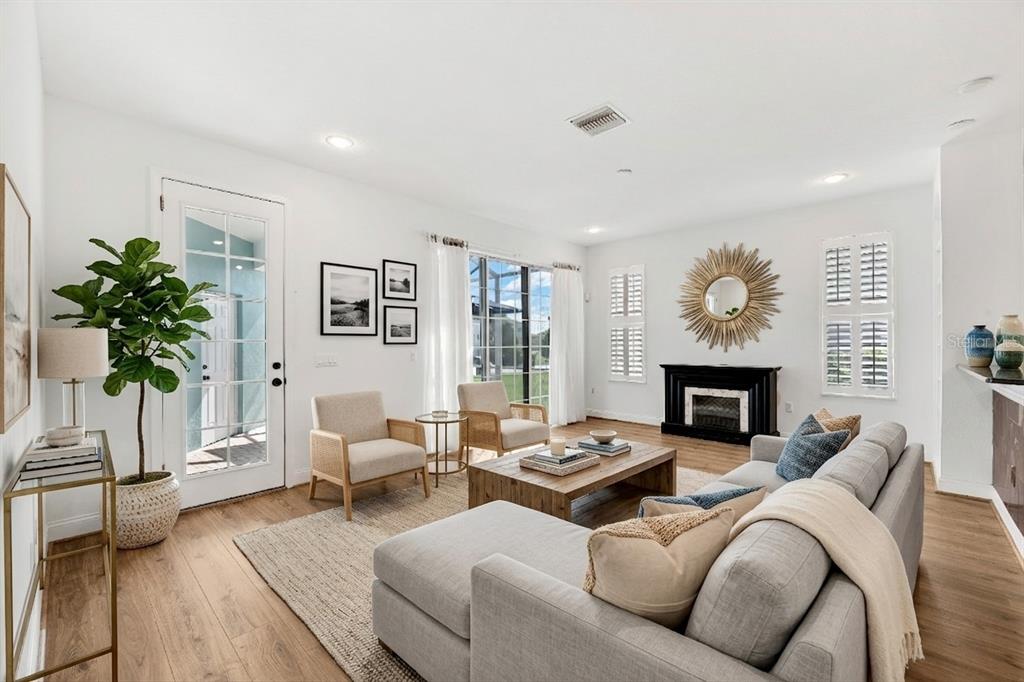 A living room features a sectional sofa, two armchairs, a fireplace, and a glass door — 5320 GOLDEN ISLES DRIVE, APOLLO BEACH, FL