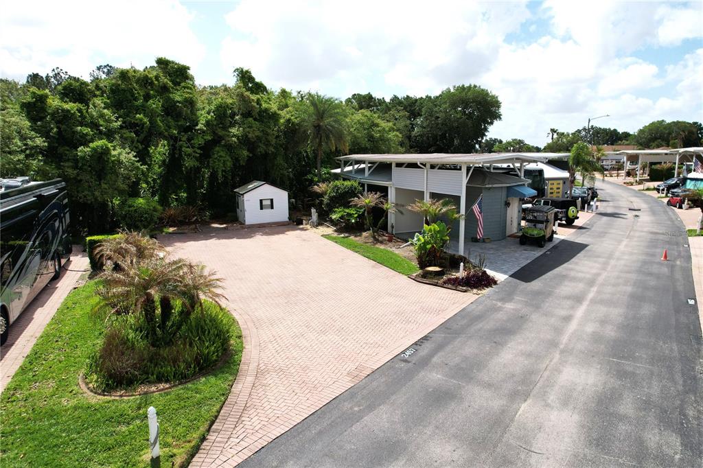 An aerial view shows a paved driveway, a small storage shed, and a covered carport — 2457 ST GEORGE DRIVE, DAVENPORT, FL