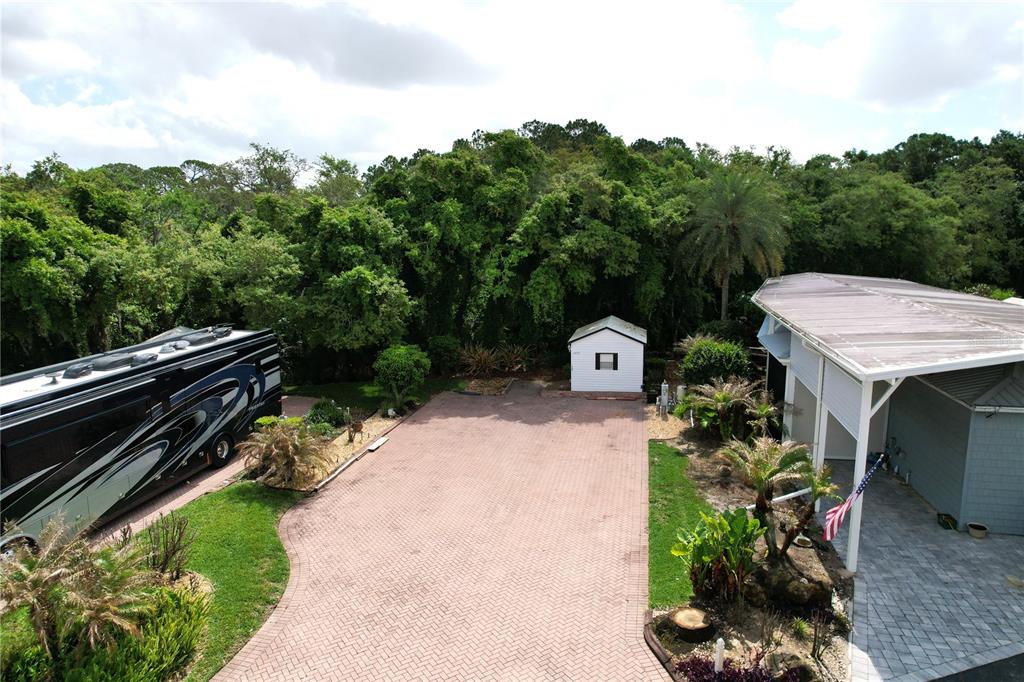 An aerial view shows a paved driveway with an RV, a shed, and a carport — 2457 ST GEORGE DRIVE, DAVENPORT, FL