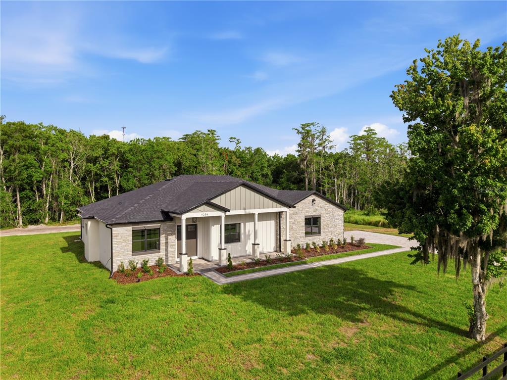 A single-story house with a stone facade and a covered entryway sits on a lawn — 4256 LA SALLE AVE, ST CLOUD, FL