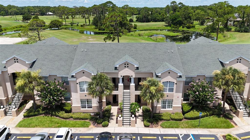 An aerial view shows the exterior of a multi-story apartment building overlooking a golf course — 1707 PRESTWICK PLACE UNIT 1707, ST AUGUSTINE, FL