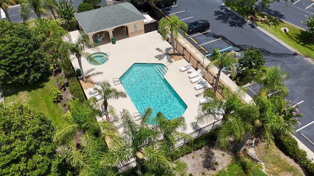 An aerial view of a swimming pool, hot tub, and covered patio area with palm trees — 1707 PRESTWICK PLACE UNIT 1707, ST AUGUSTINE, FL