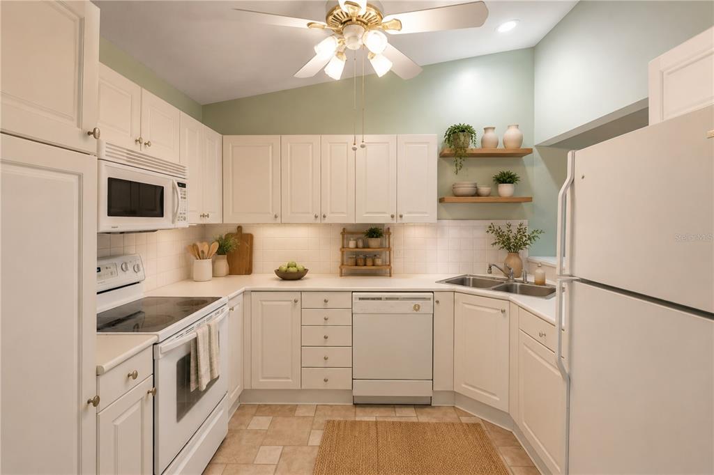 A kitchen with white cabinets, white appliances, light tile flooring, and open wood shelving — 30 LANDINGS LANE UNIT 30, ORMOND BEACH, FL