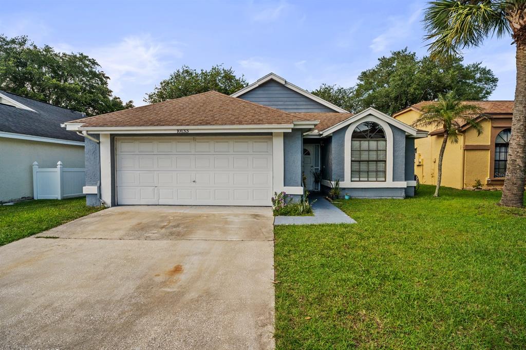 A single-story house with a two-car garage, brown roof, and a front arched window — 10133 MARGUEX DRIVE, ORLANDO, FL
