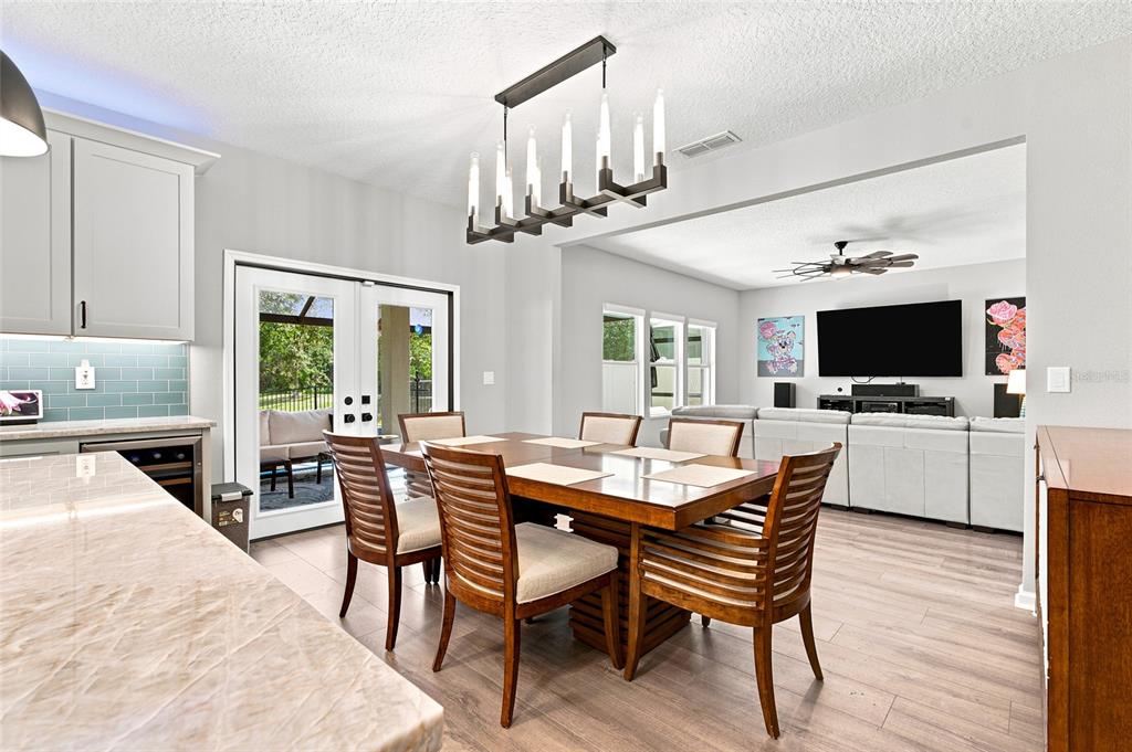 A dining area with a wooden table and chairs sits adjacent to a living room — 48 MISSION OAK COURT, ST AUGUSTINE, FL