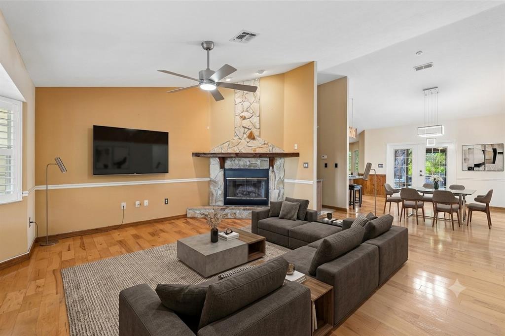 A single-story house with a gravel driveway and a detached garage surrounded by large trees — 204 JEFFERSON DRIVE, LAKE PLACID, FL